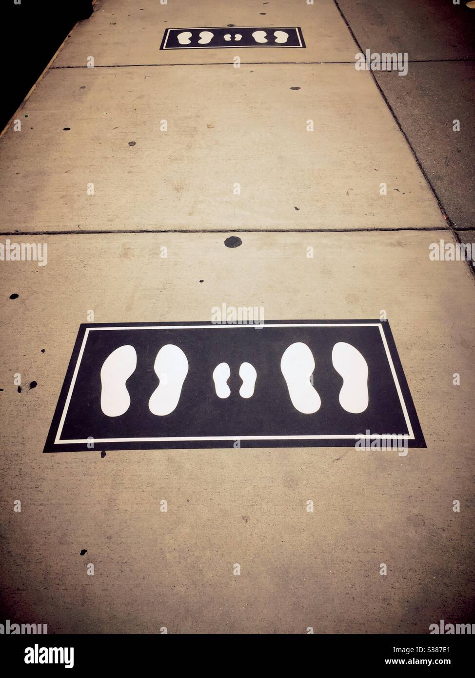 Social distancing foot prints showing the proper 6 feet apart necessary to enter an office building in midtown Manhattan during the pandemic, 2020, NYC, USA - Smartphone Captured Stock Image