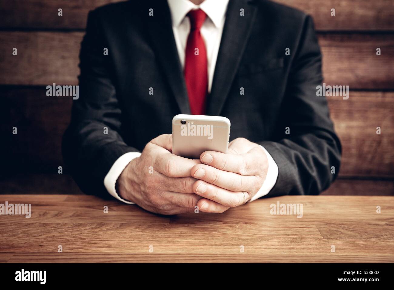 A male businessman sitting and texting on his mobile phone with copy space - Smartphone Captured Stock Image