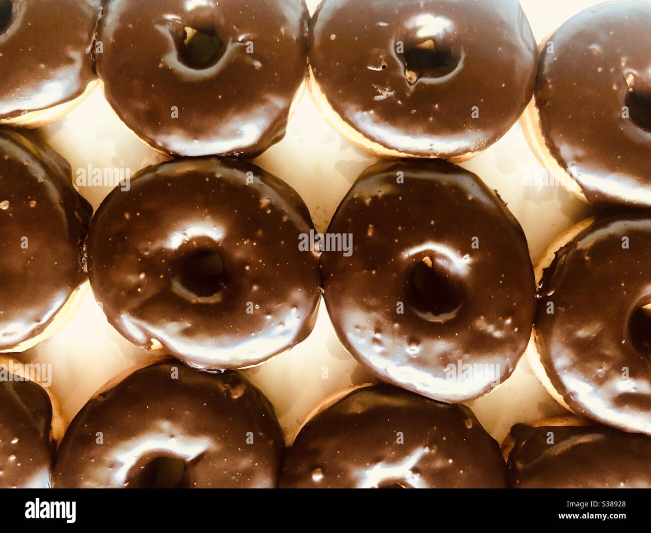 Top view of a full frame of chocolate covered donuts in a white box Stock Photo