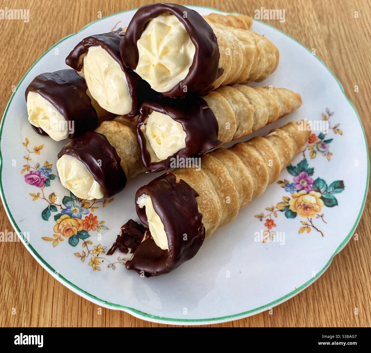 Cream horn pastries on flower patterned plate Stock Photo Alamy