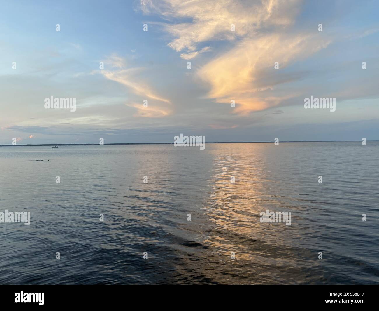Colorful evening skies with bright clouds and reflections onto bay water - Smartphone Captured Stock Image