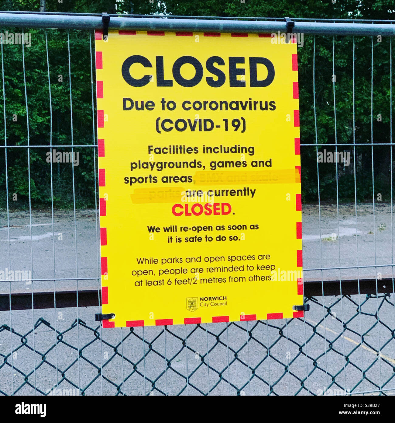 A sign on a tennis court, which says closed due to Coronavirus. It also provides a reminder about social distancing. Norfolk UK. Stock Photo