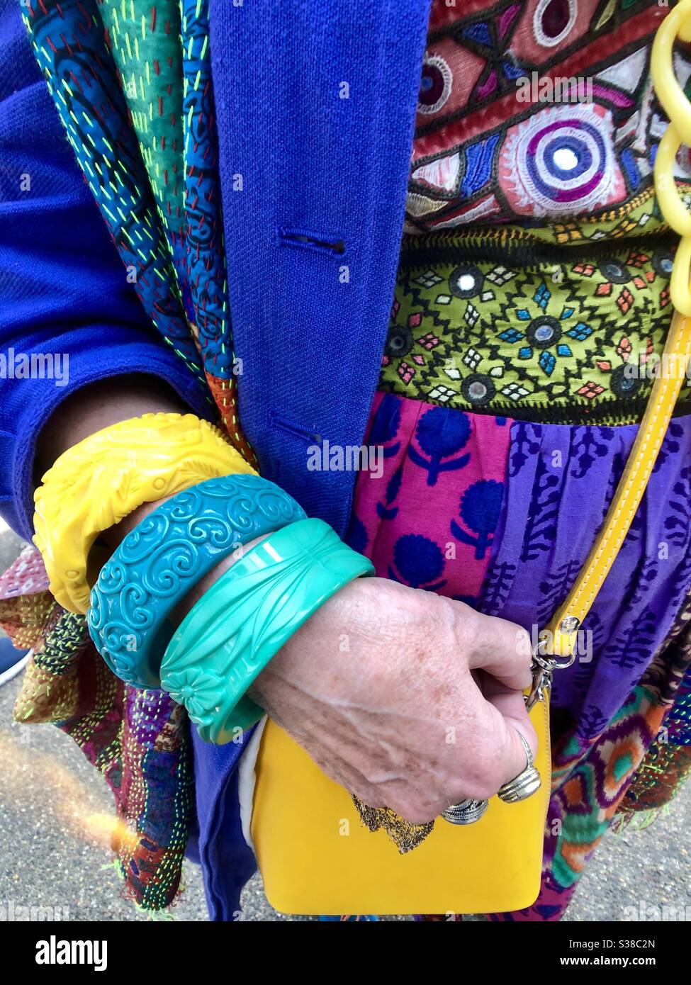 Bright colorful clothing and accessories on woman at London’s Spitalfields Market Colourwalk event - Smartphone Captured Stock Image
