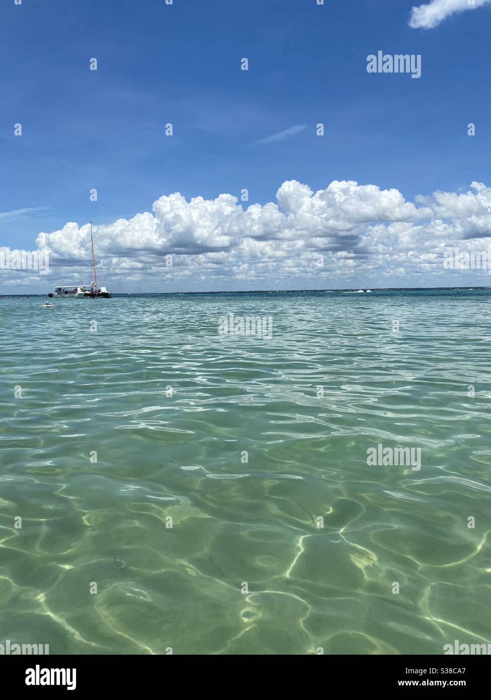 Crystal clear emerald colored water at Crab Island Destin, Florida with distant boats on water - Smartphone Captured Stock Image