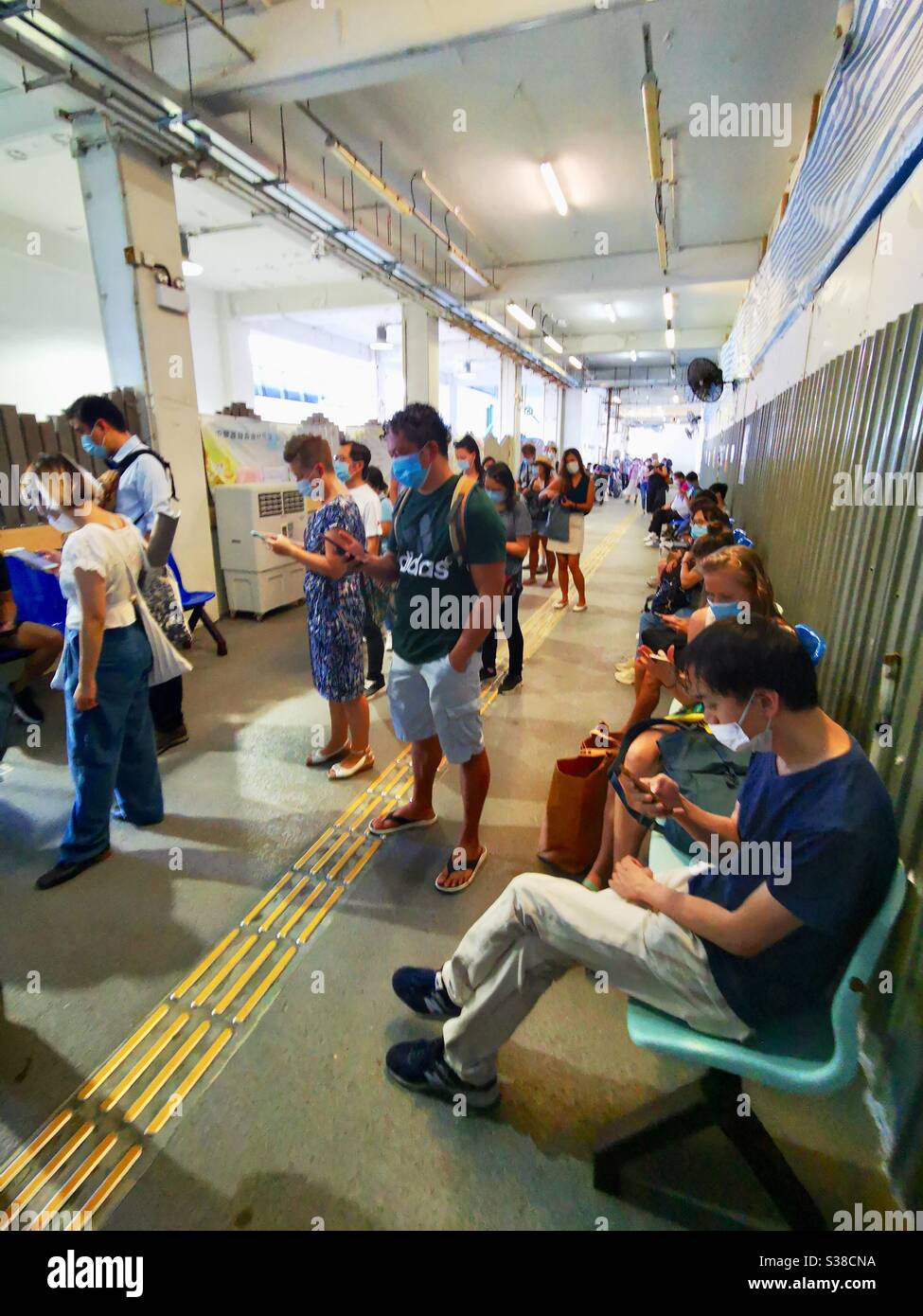 Passengers waiting for the ferry from Lamma Island to central during the third wave of the covid 19 pandemic. - Smartphone Captured Stock Image
