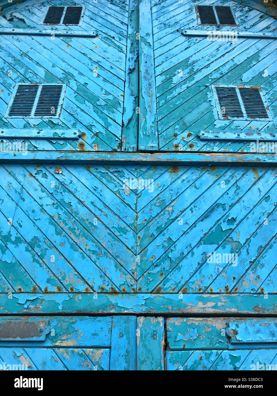 Old wooden doors with peeling blue paint. - Smartphone Captured Stock Image