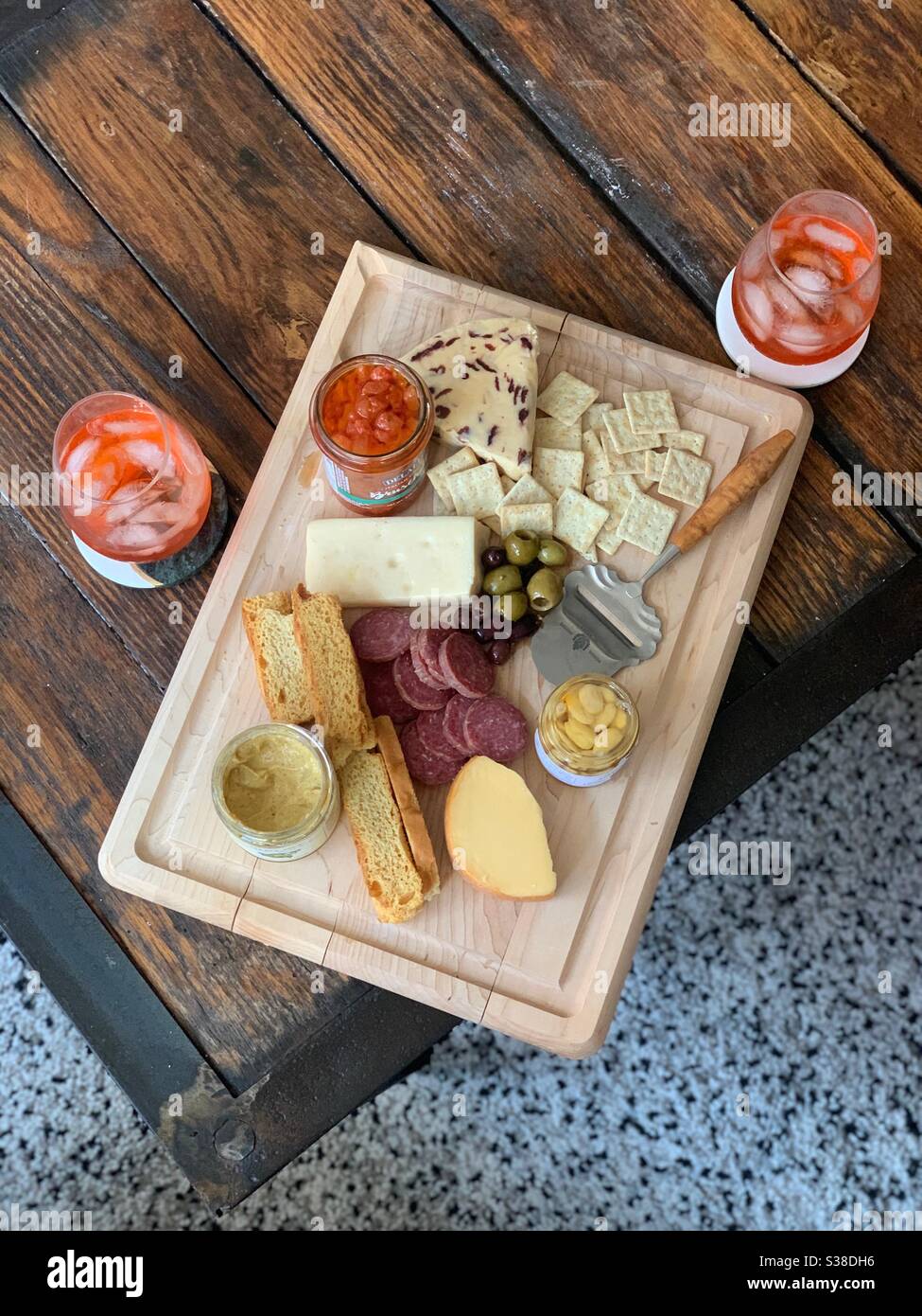 An overhead view of a charcuterie board with cheeses, salami, olives, etc and two glasses of wine Stock Photo