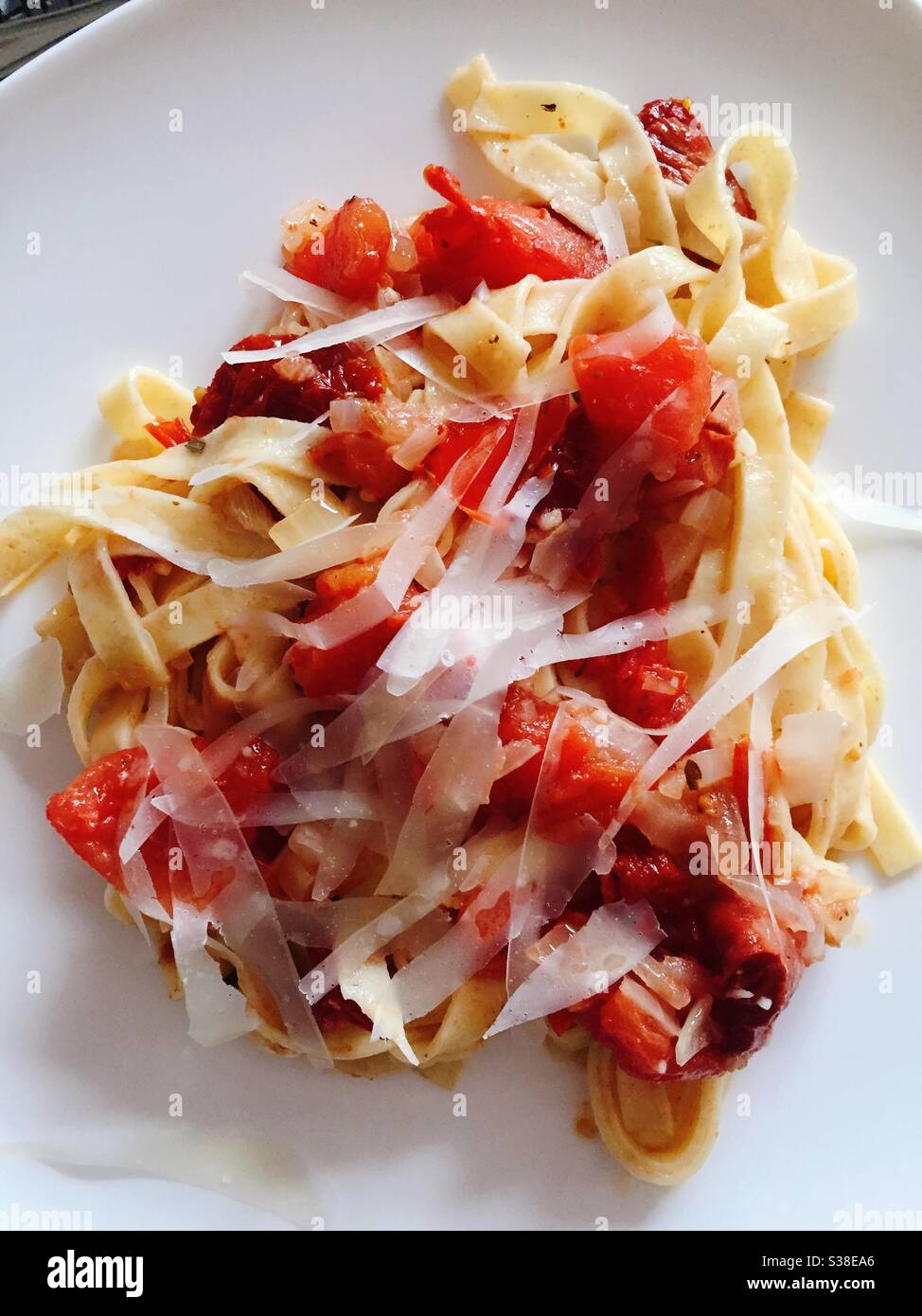 Flat plate of a Italian pasta dish of fettuccine with the sun-dried tomato sauce and shaved Parmesan cheese - Smartphone Captured Stock Image