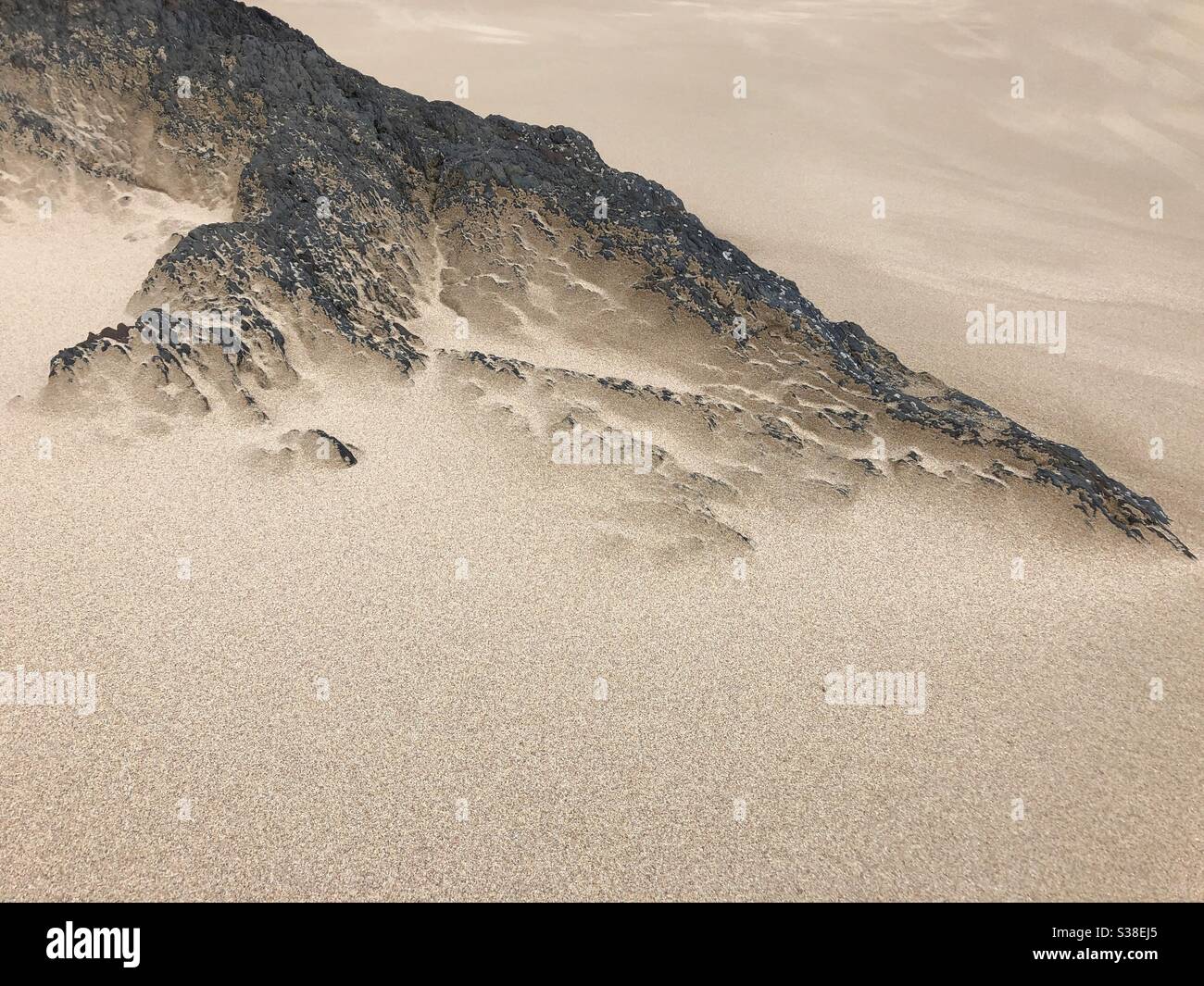 Wind blown sand on rocks Stock Photo