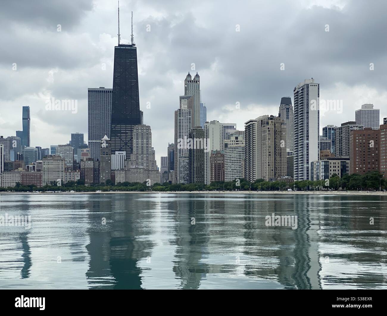 Looking across calm waters & stormy sky at Chicago skyline Stock Photo