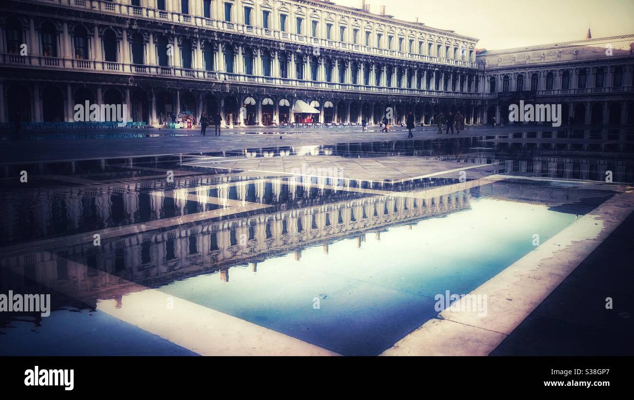 A photograph of high water flooding, ‘acqua alta’ in Venice, Italy, with reflections of the palazzos. St Mark’s Square. Piazza San Marco. - Smartphone Captured Stock Image