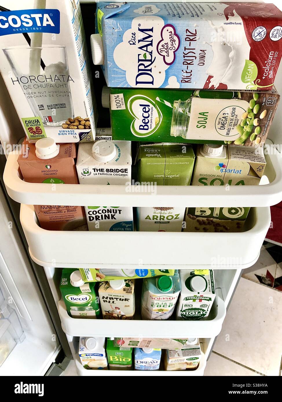 Fridge door full of cartons of alternative plant-based milk products. Stock Photo