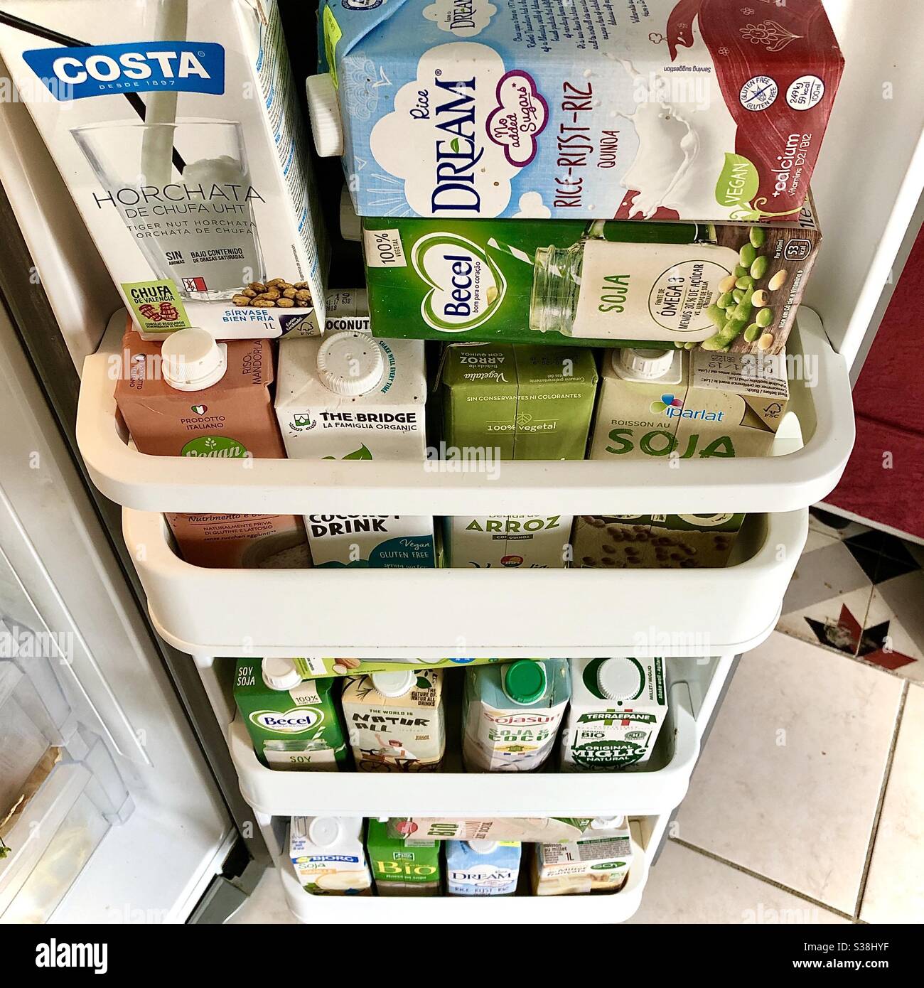 Refrigerator door filled with cartons of healthy plant-based alternative milks in preparation for Covid virus lockdown and shops running out of supplies. Stock Photo