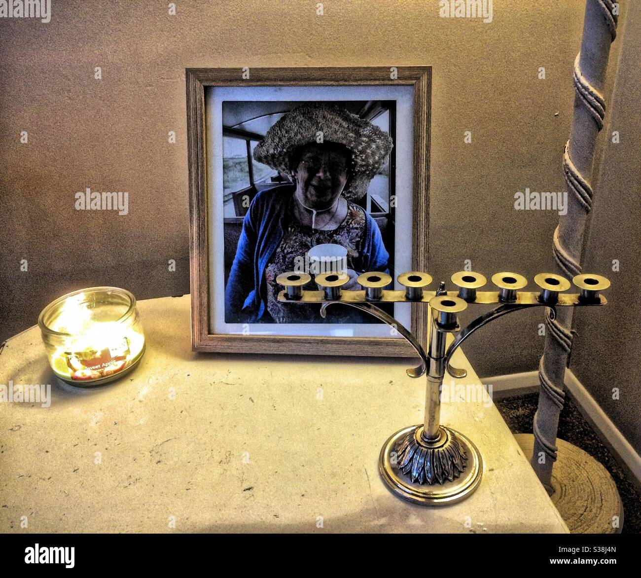My family’s Menorah, in front of a picture of my dead sister with a lit, scented candle next to it - Smartphone Captured Stock Image
