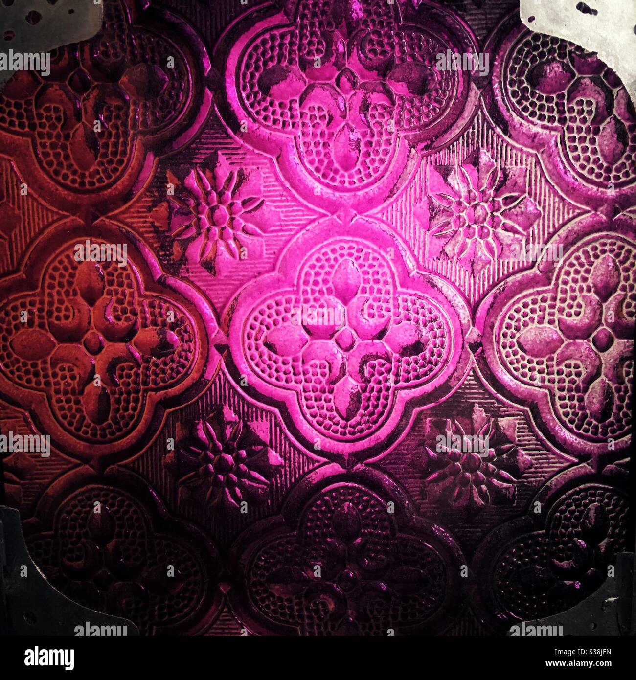 A close up photograph of detail of a glass Moroccan lamp. Beautiful pink and red hues and stunning decorative pattern. - Smartphone Captured Stock Image