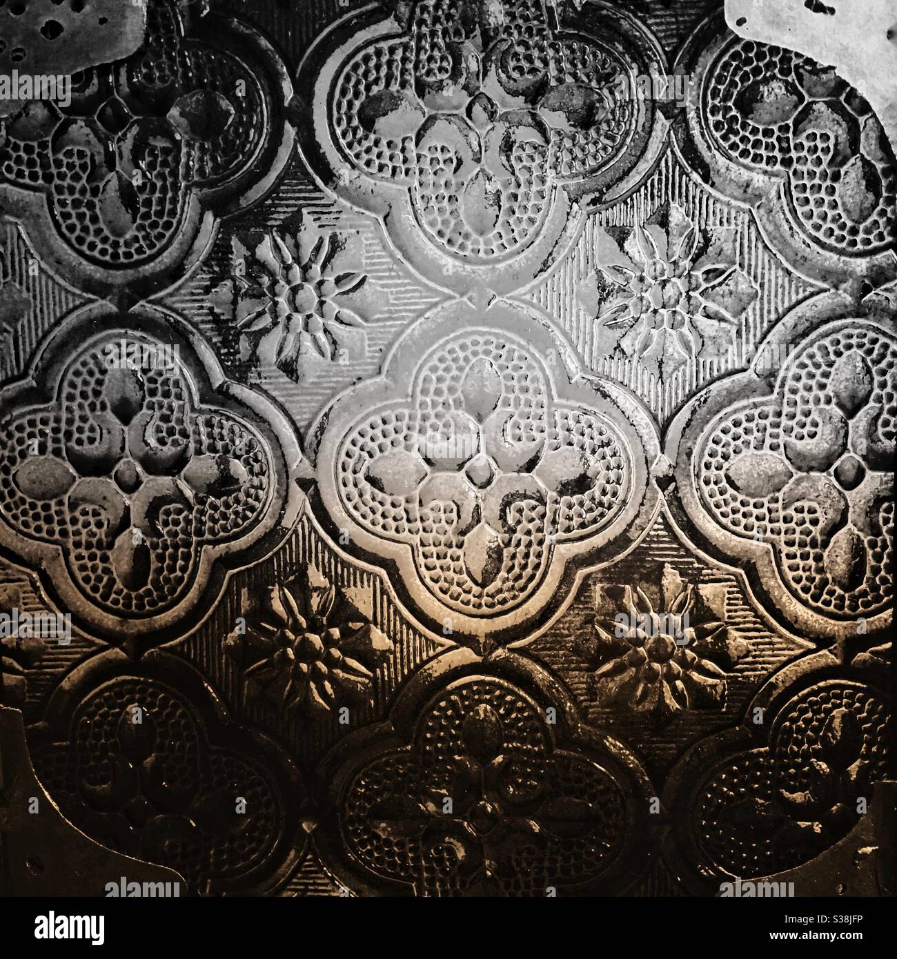 A close up photograph of a Moroccan glass lamp, in black and white and sepia tones. Stock Photo