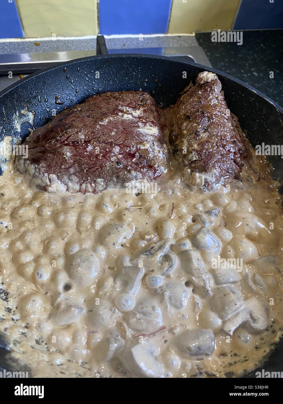 Denver Steak and Diane Vermouth Sauce bubbling in the pan Stock Photo
