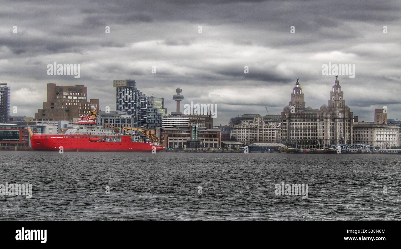 RRS Sir David Attenborough berthed at Liverpool Cruise Terminal being passed by Mersey Ferry Stock Photo