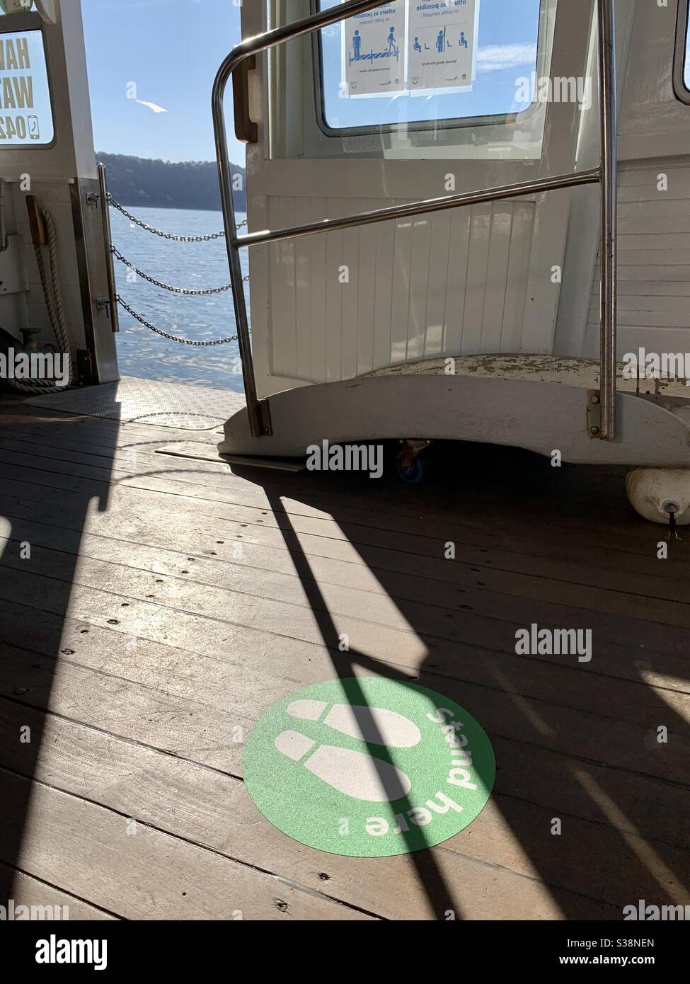A COVIDSafe sticker or decal on the floor of the Dangar Island ferry serves to help people keep safely apart when travelling. - Smartphone Captured Stock Image