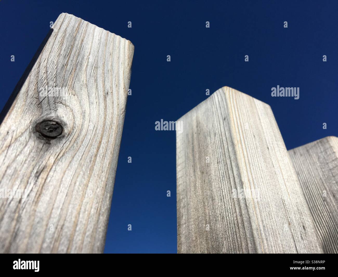 Wooden fence posts against deep blue sky - Smartphone Captured Stock Image