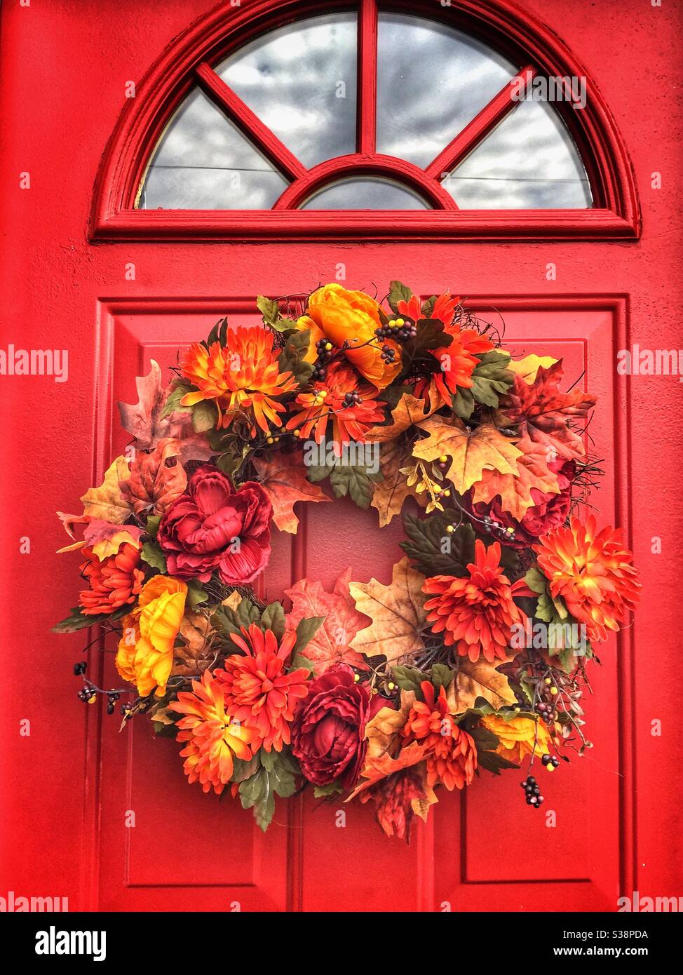 Autumn style wreath on a red front door of a home. - Smartphone Captured Stock Image