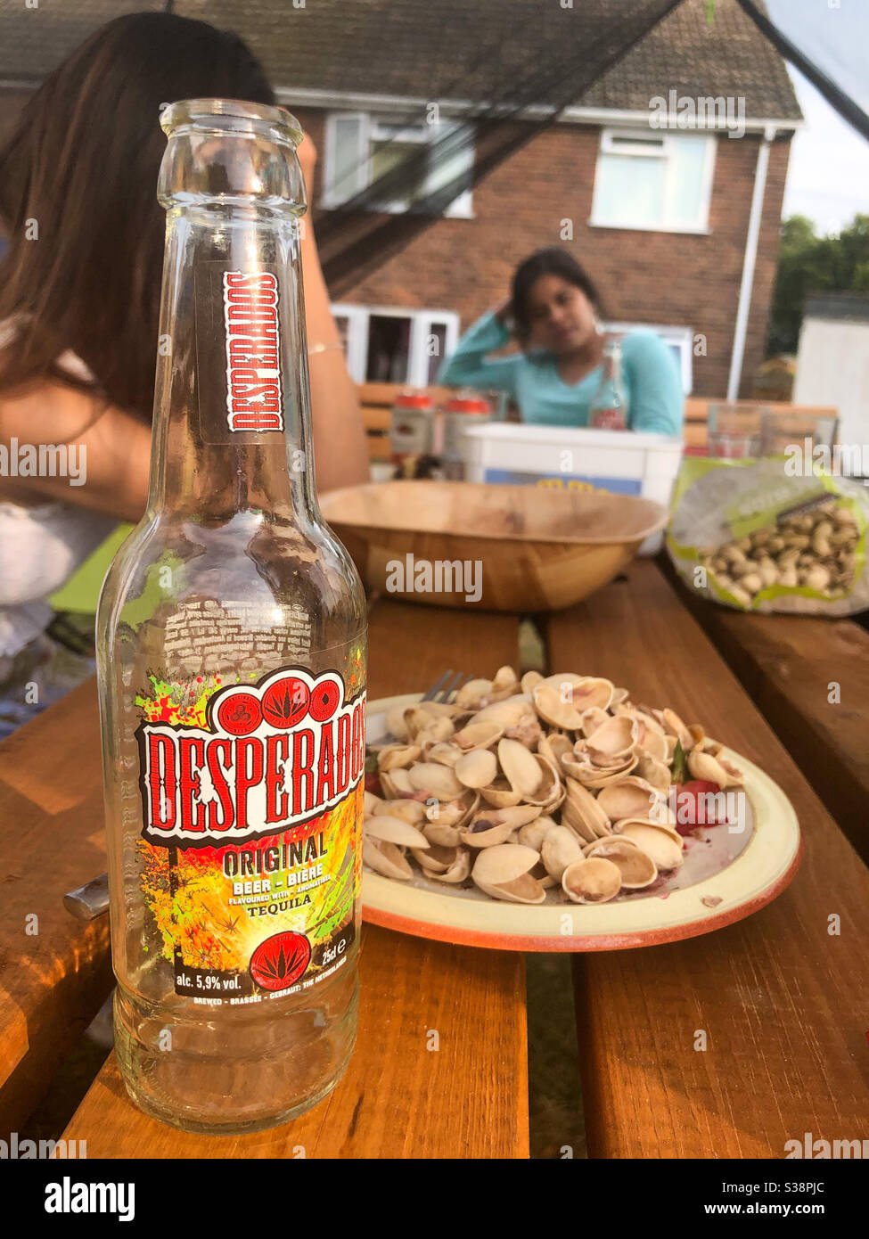 Drinking Desperado beer and eating pistachios outside in the garden with friends. - Smartphone Captured Stock Image