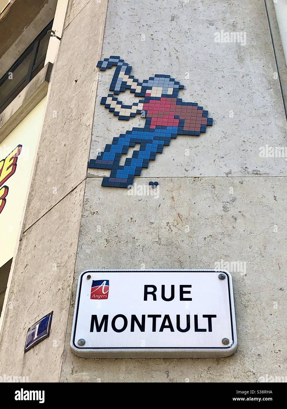 Ceramic tiles depiction of a rock climber - probably by « Invader » - above Rue Montault... derived from monter in French meaning ´to climb’. Stock Photo