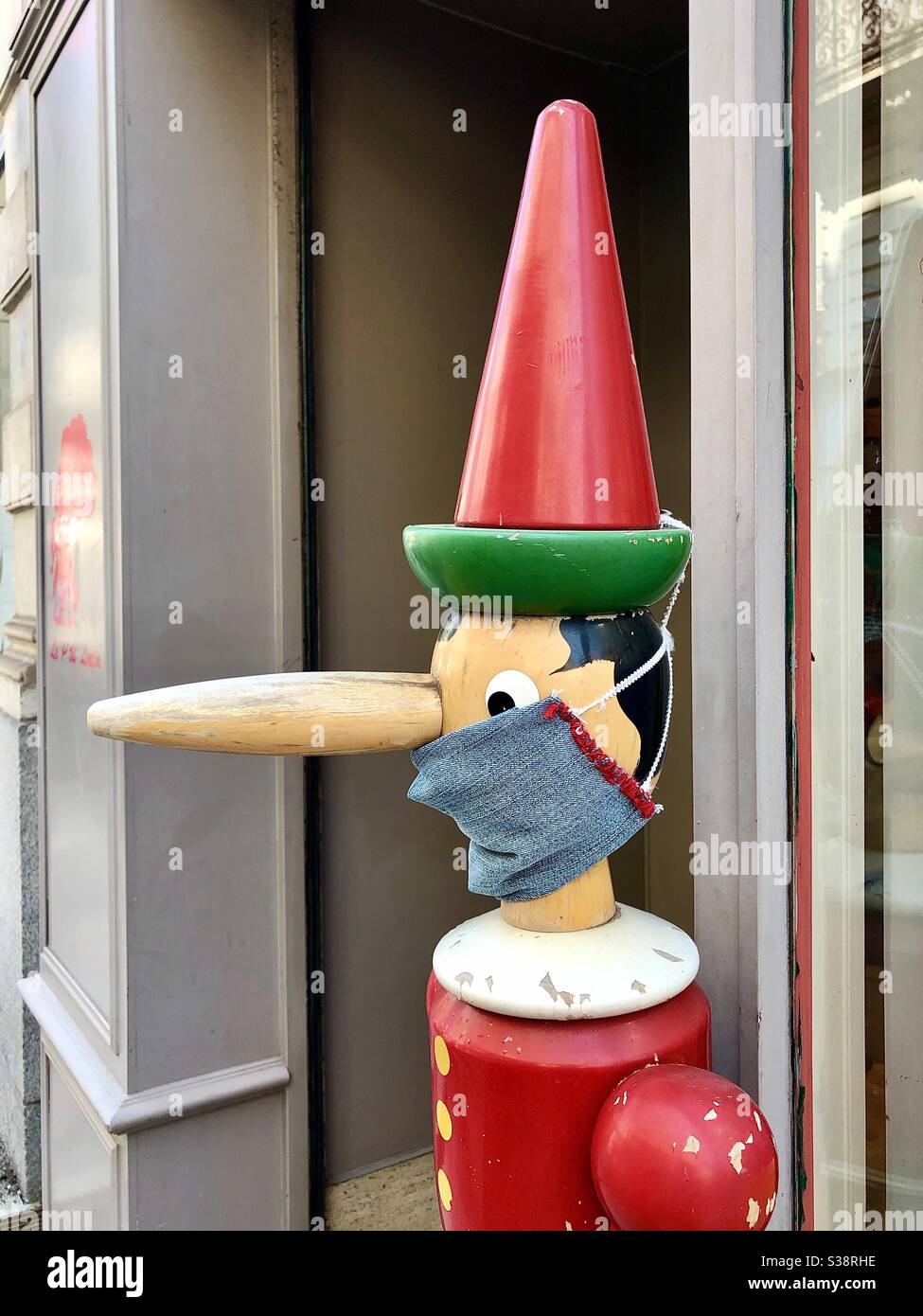 Pinocchio figure wearing COVID-19 face mask protection outside the Jeu Jouet toy shop, Rue de l’Aiguillerie, Angers, Maine-et-Loire, France. - Smartphone Captured Stock Image