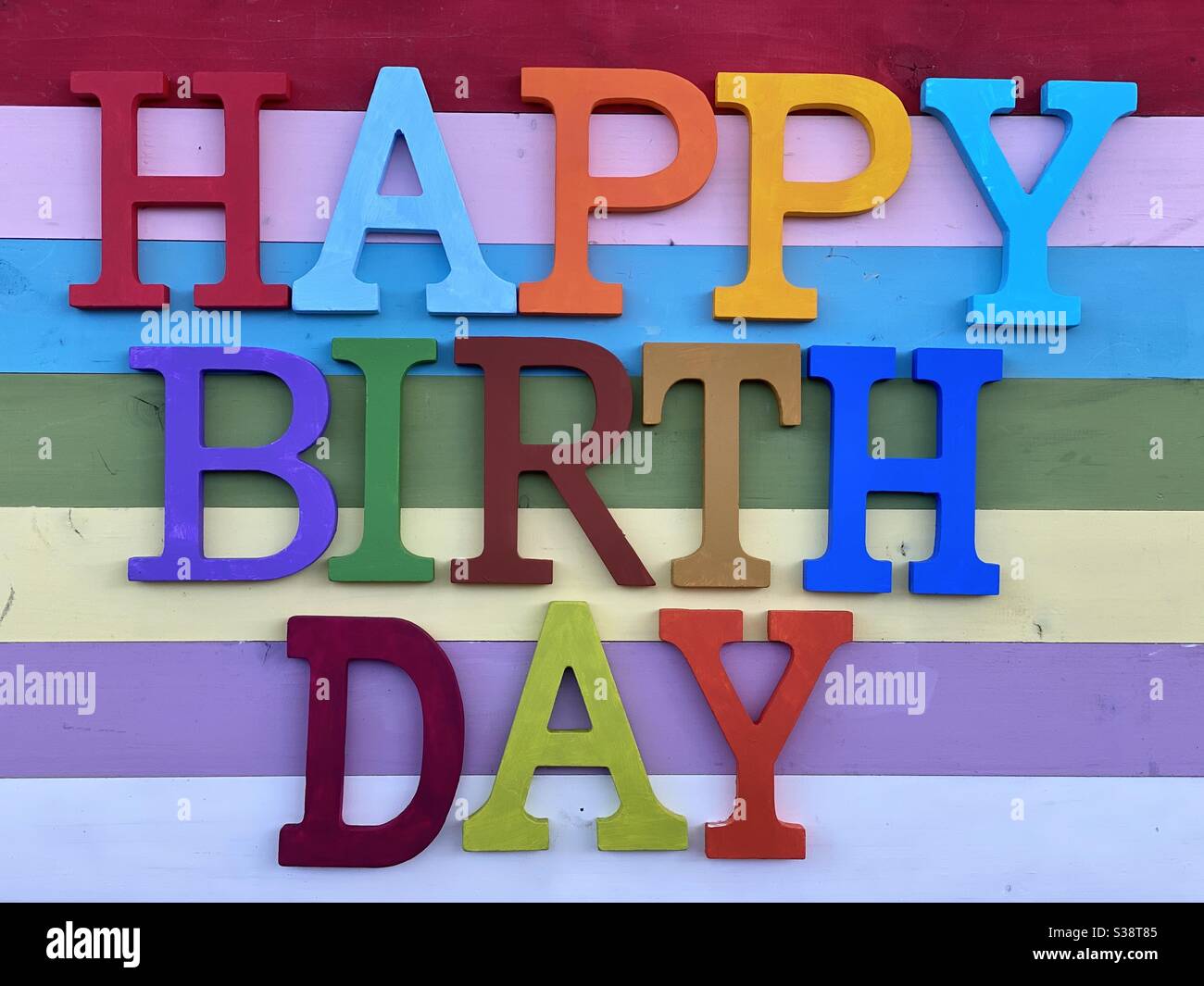 Happy Birthday composed with multicolored wooden letters over a colorful wooden board - Smartphone Captured Stock Image