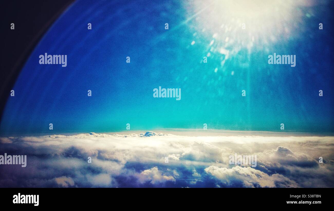 A photograph of clouds from above, looking out the window of an aeroplane. - Smartphone Captured Stock Image