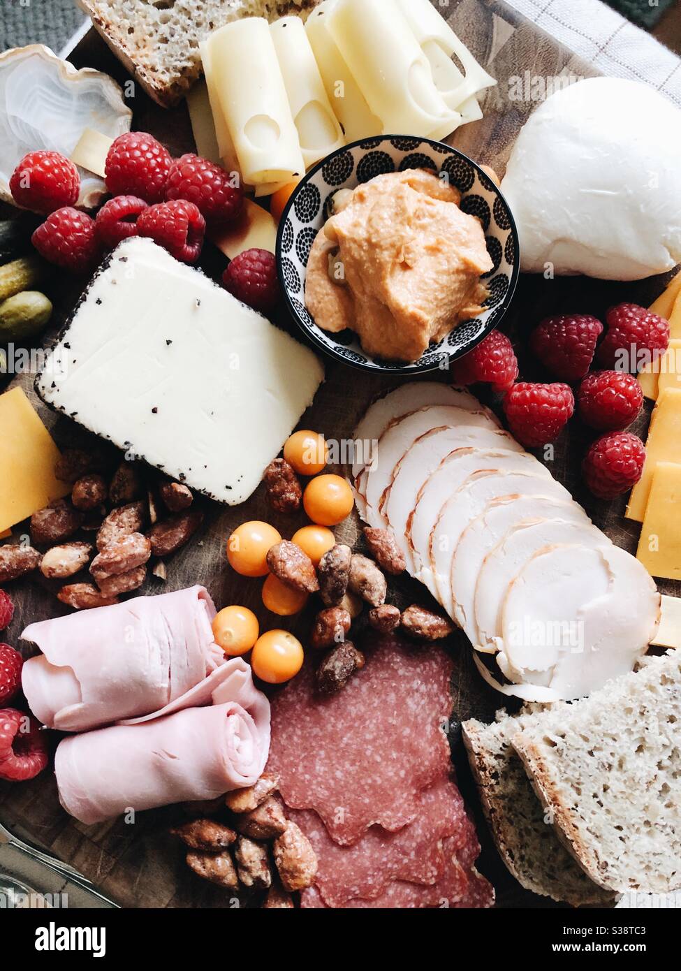 Meat, cheese, fruit and nut charcuterie board - a hot weather Italian meal when you don’t want to cook. Stock Photo