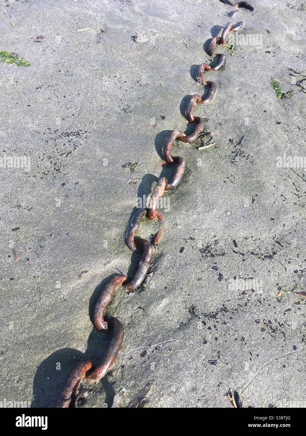 Metal chain buried in sand - Smartphone Captured Stock Image