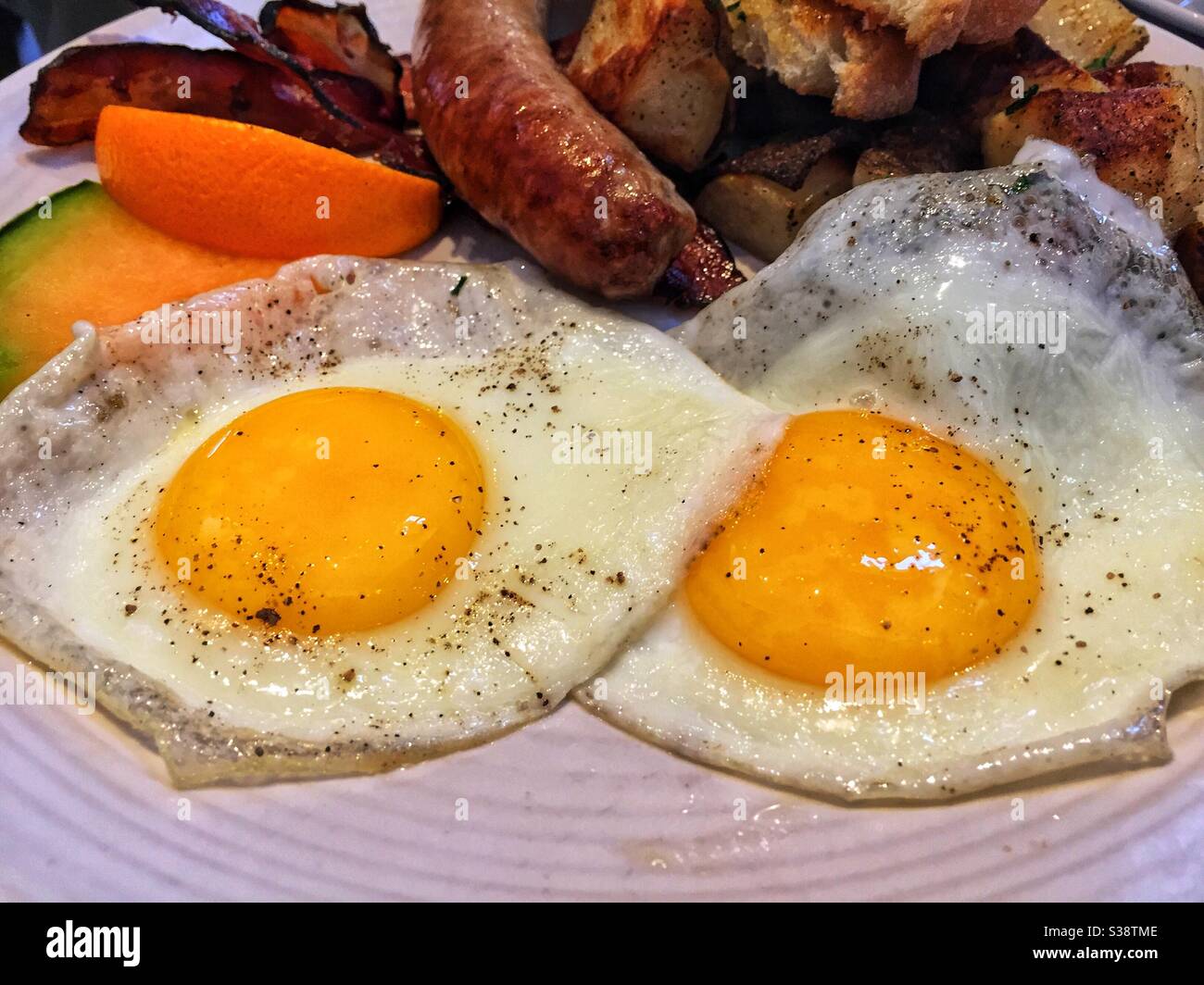Two fried eggs with a side of sausage. - Smartphone Captured Stock Image