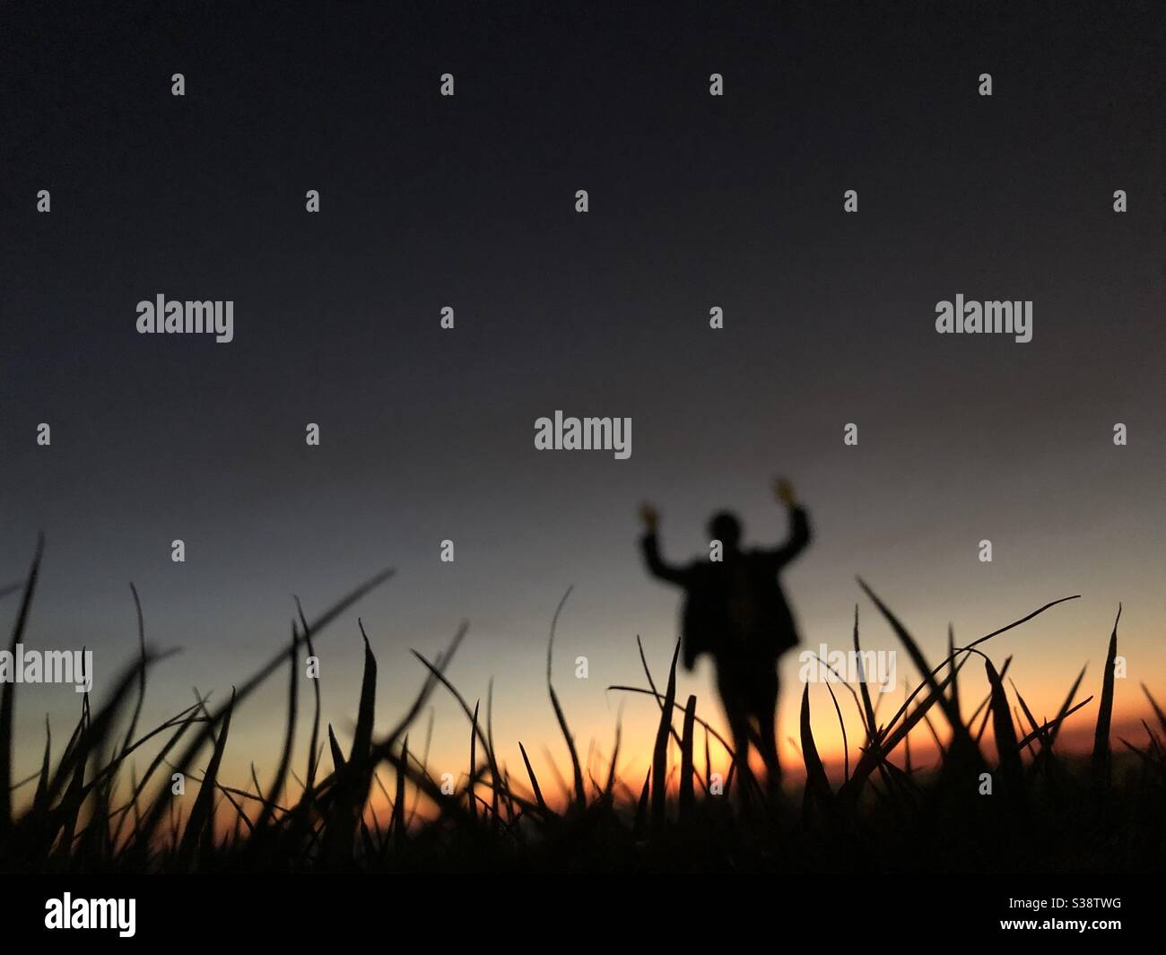 Silhouette of a person weaving her arms at sunset - Smartphone Captured Stock Image