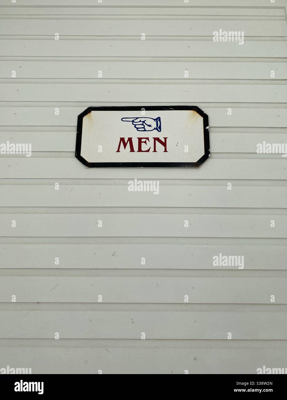 Men’s restroom sign with hand pointing direction - Smartphone Captured Stock Image