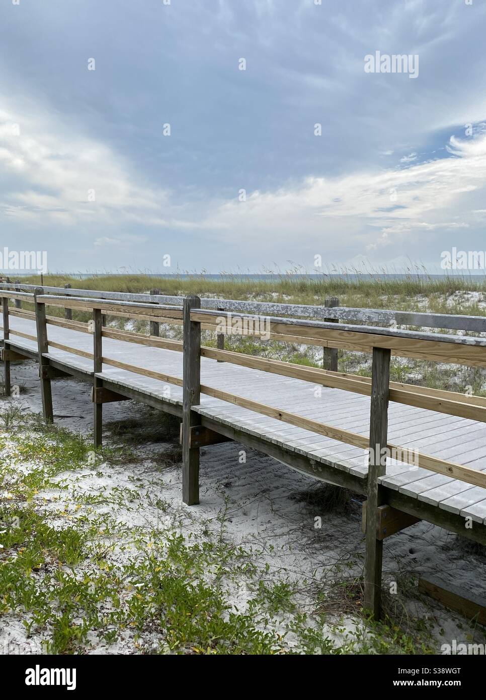 Long wooden bridge over white sand dunes on Florida beach - Smartphone Captured Stock Image