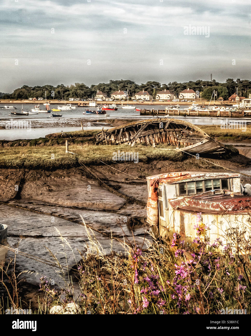 Old shipwrecks and decaying boats in the mud at low tide on the Suffolk coast Stock Photo