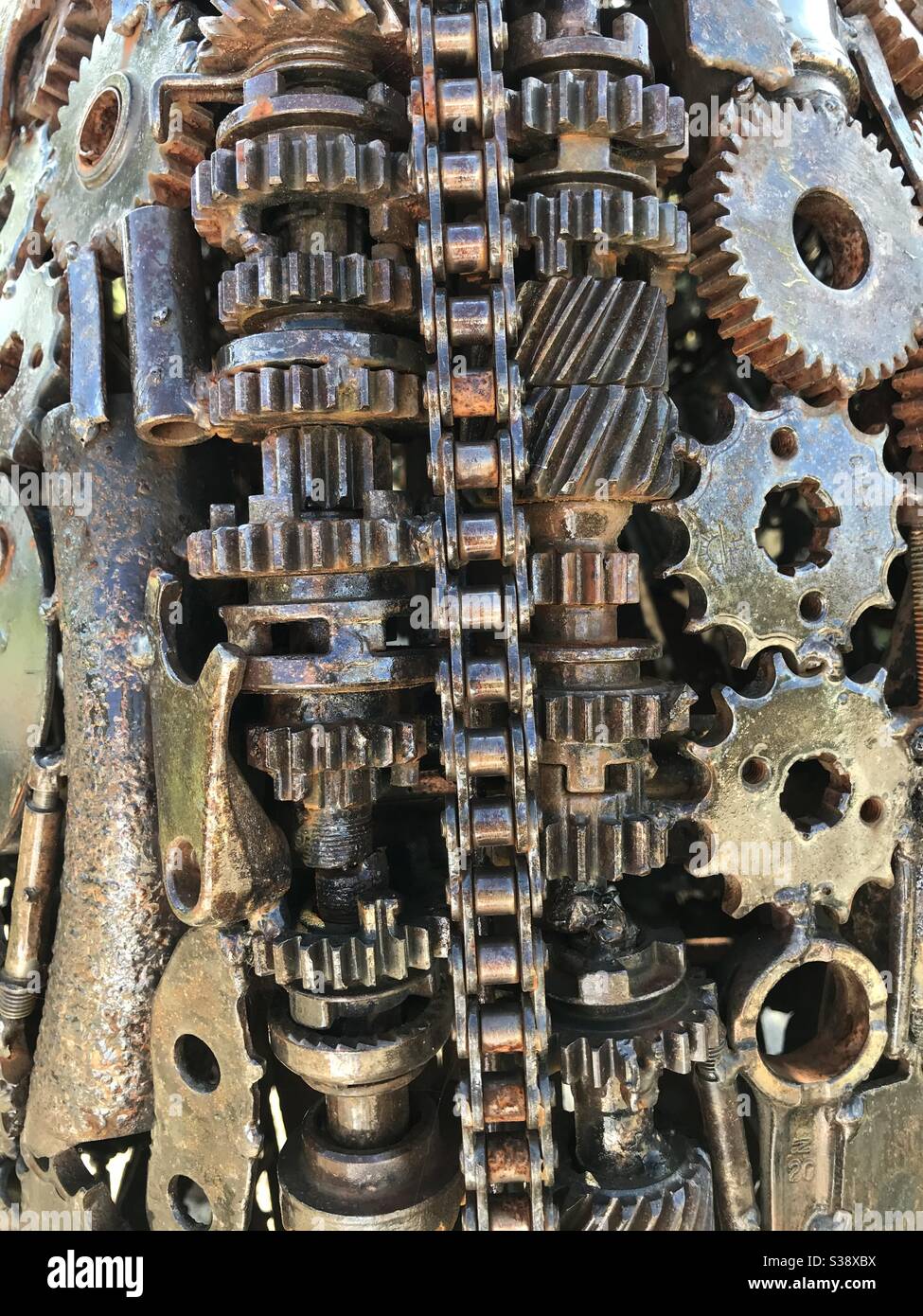 Selection of metal chains, cogs, wheels, nuts and bolts. Treated with