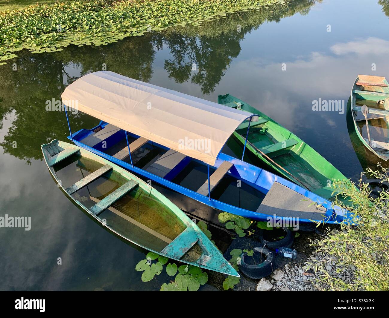 Boats floating on river with lots of pond lilies - Smartphone Captured Stock Image