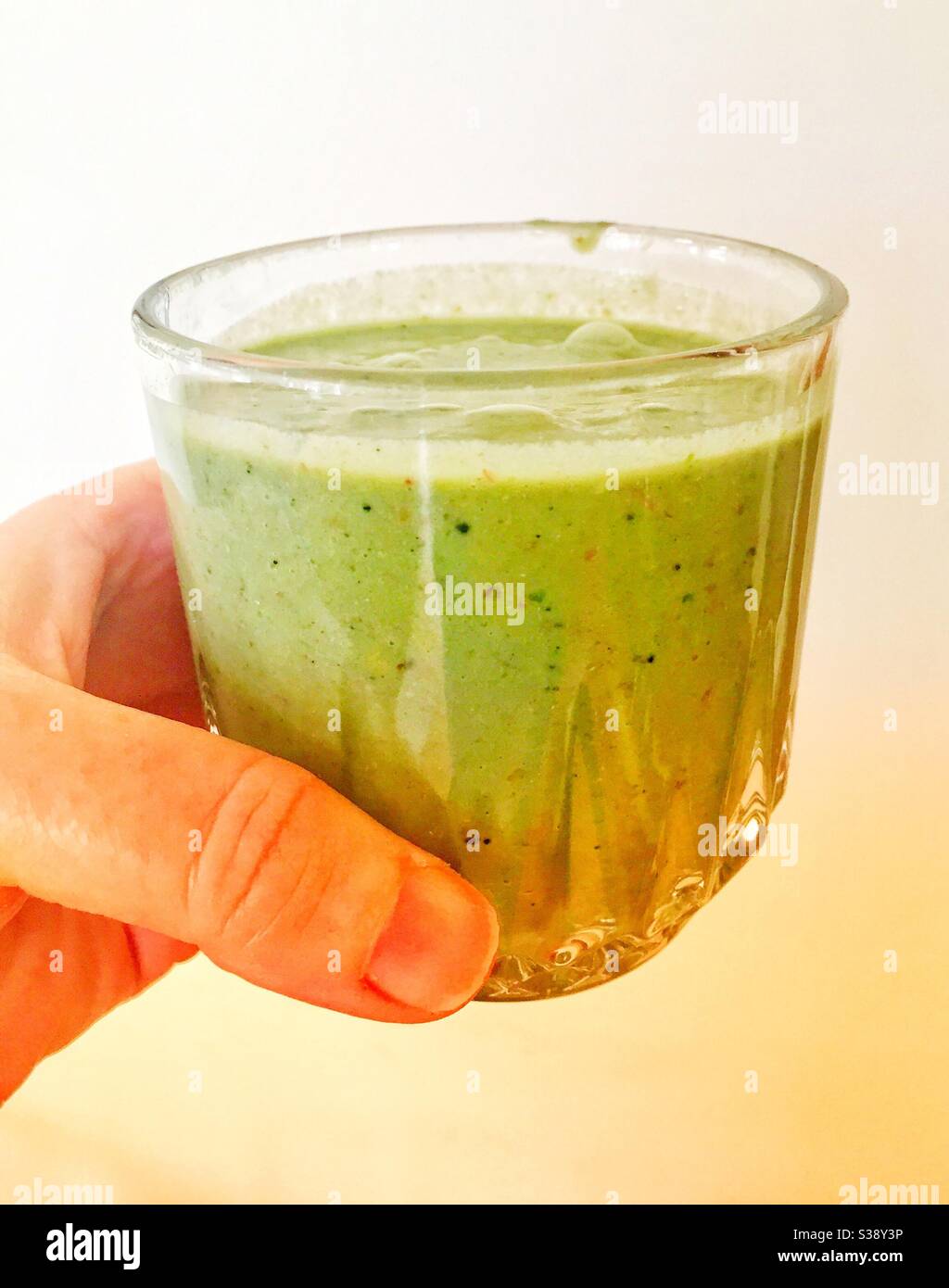 Healthy spinach smoothie with lots of bits of ground vegetables. - Smartphone Captured Stock Image