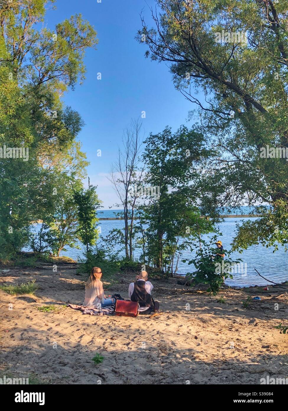 A couple sitting in the sand at Sunnyside Beach in Toronto, Ontario, Canada. Stock Photo