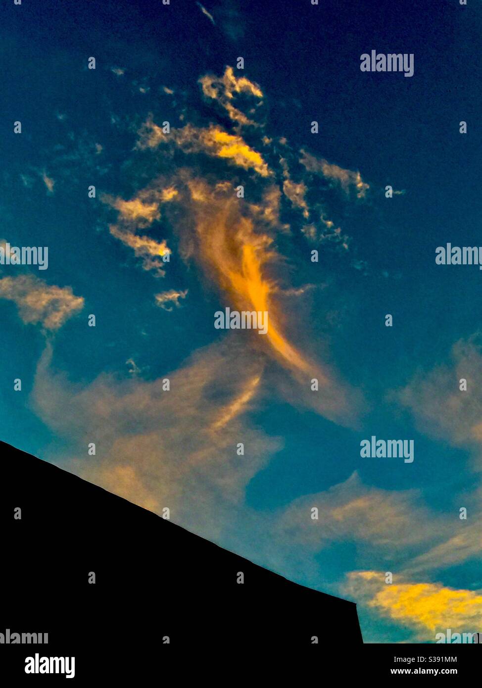 Whisky ,clouds, drifting by, sunset colours, blue sky, orange cloud - Smartphone Captured Stock Image