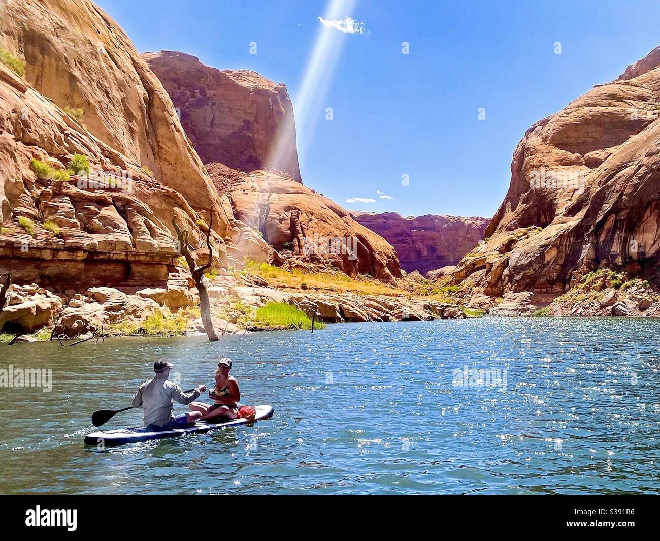 Stand up paddle board in a canyon on a sunny day. Water recreation on a summer day. Lake Powell in Utah, USA. Stock Photo