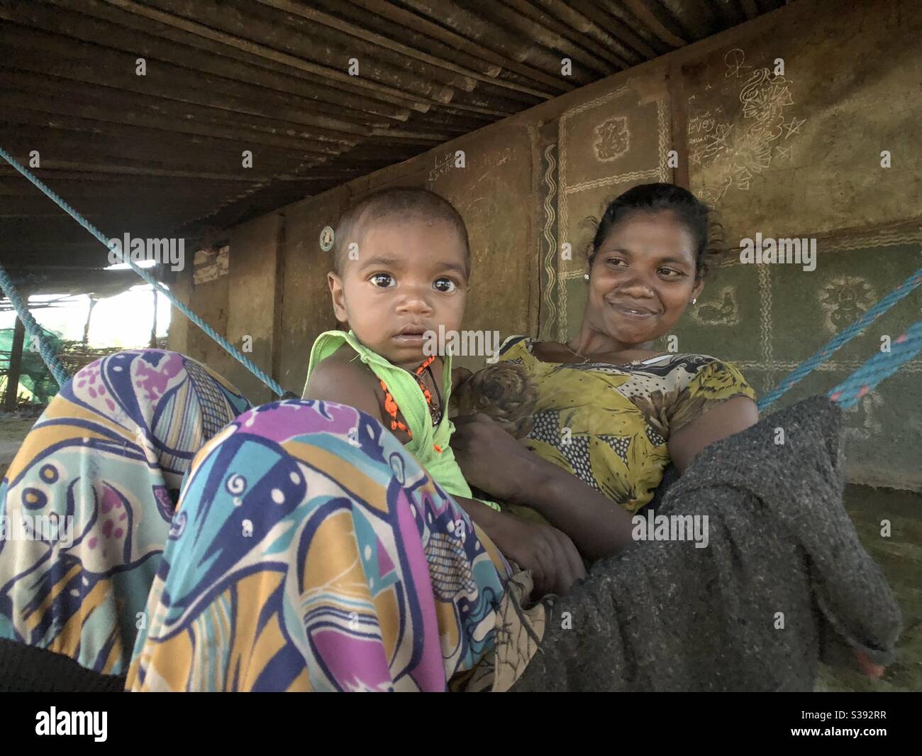 Tribal woman is seen relaxing with her child in tribal area of Dangs, Gujrat, India Stock Photo