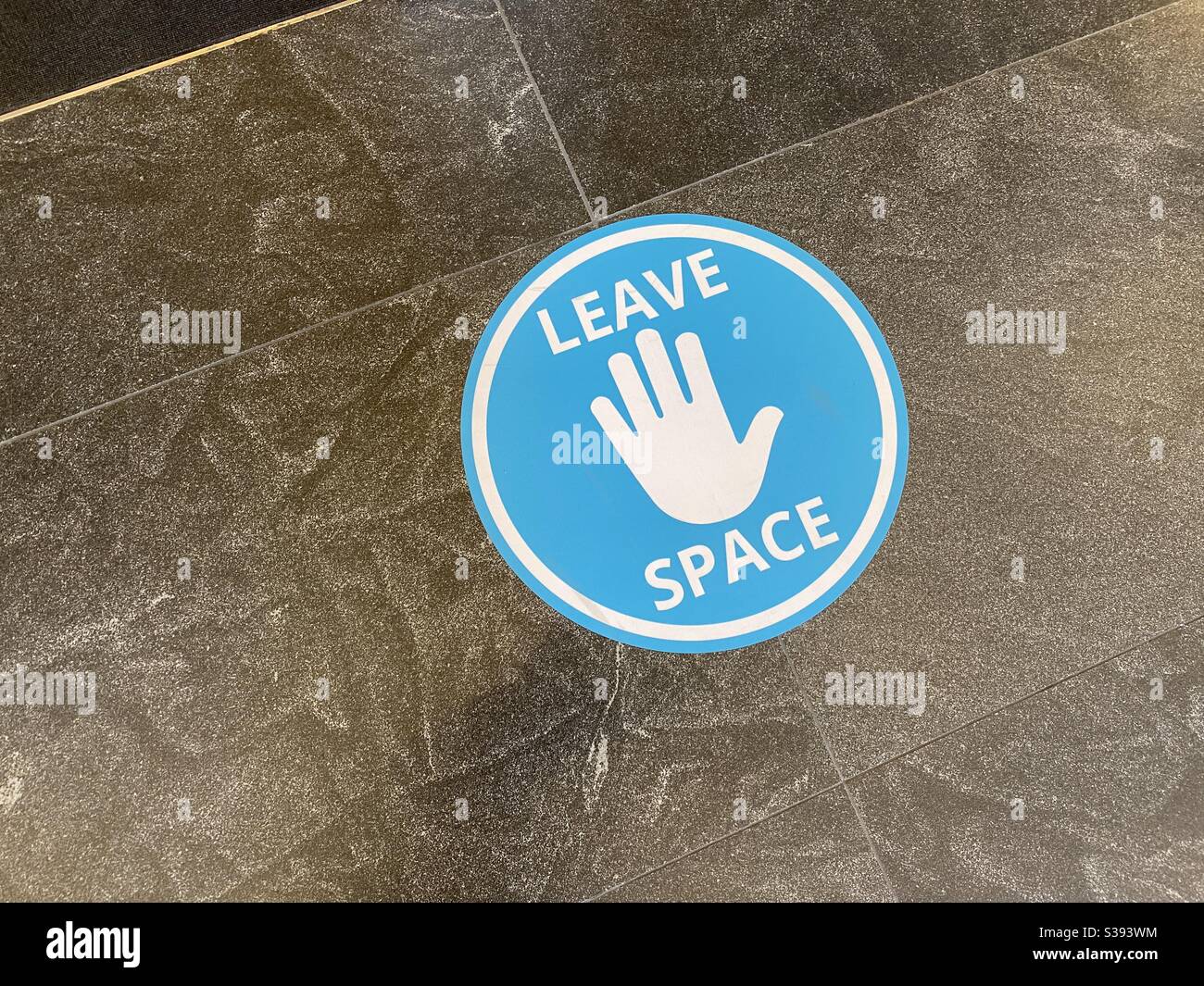 LOS ANGELES, CA, JUN 2020: blue sign with white hand on floor reminding people to maintain social distancing during Covid-19 viral pandemic - Smartphone Captured Stock Image
