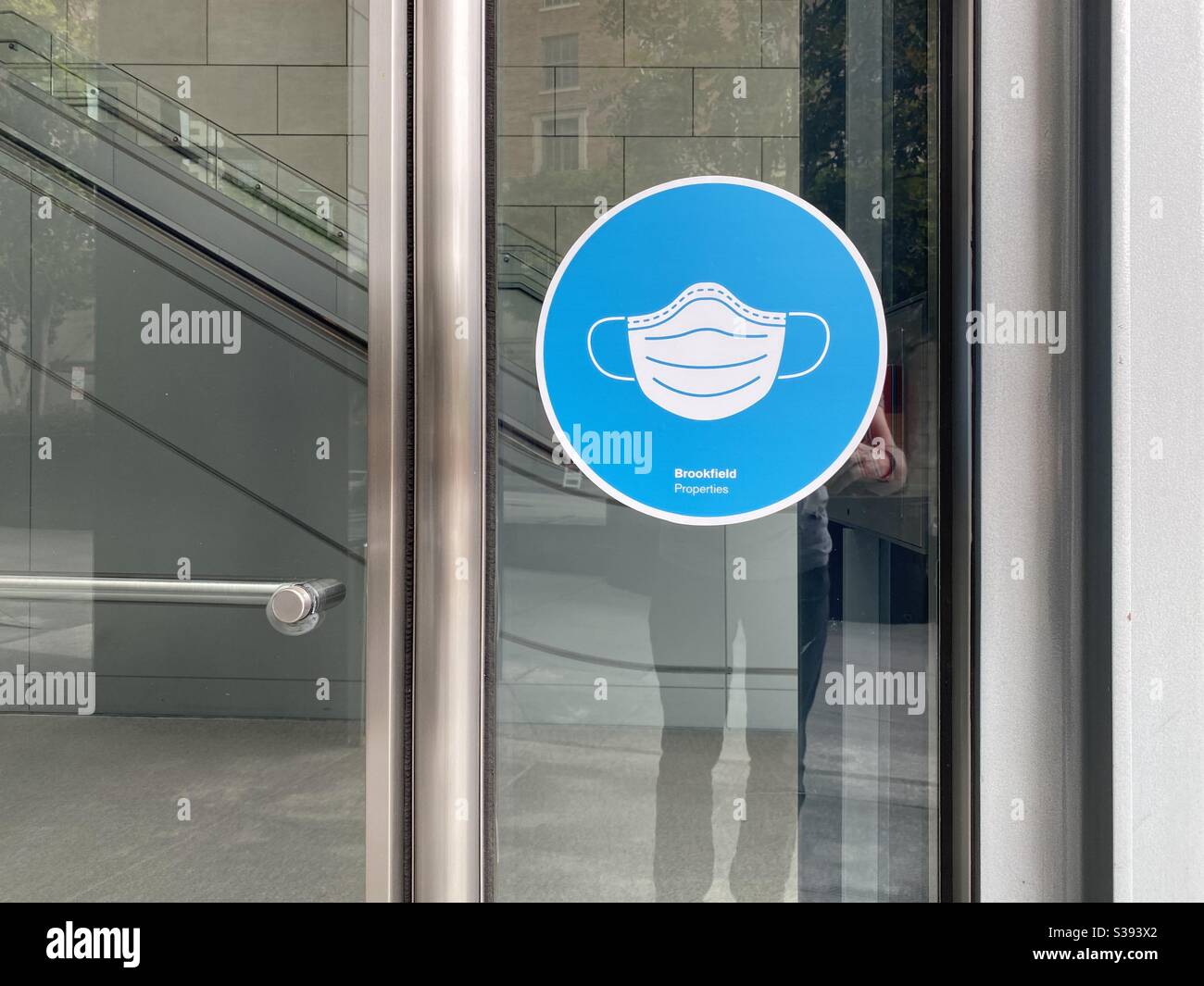 LOS ANGELES, CA, JUN 2020: blue window sign at office entrance indicates masks required during Covid-19 viral pandemic in Downtown - Smartphone Captured Stock Image