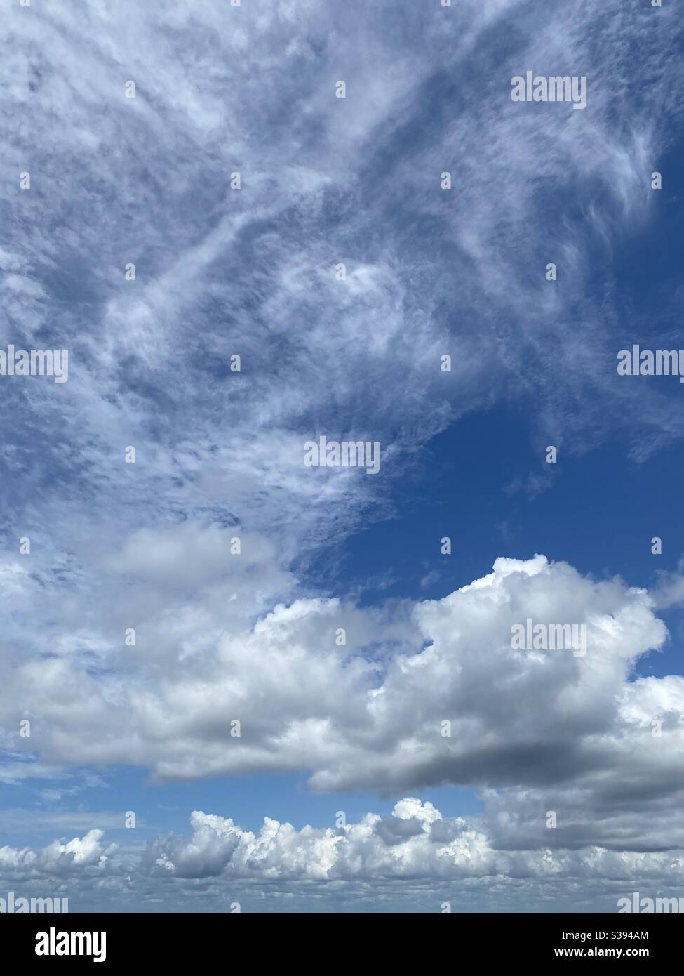 Large white cloud formations against blue sky background - Smartphone Captured Stock Image
