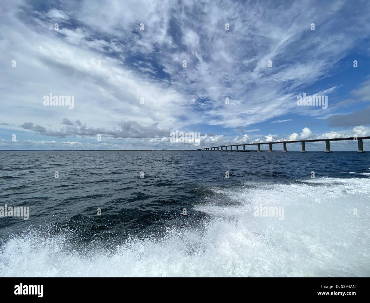 Perspective photography using long exposure on iPhone of Gulf of Mexico water and Destin Florida bridge from a boat view Stock Photo