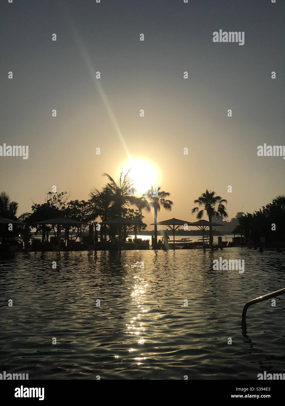 Sunset and Palm trees in a luxury resort by a pool Stock Photo Alamy