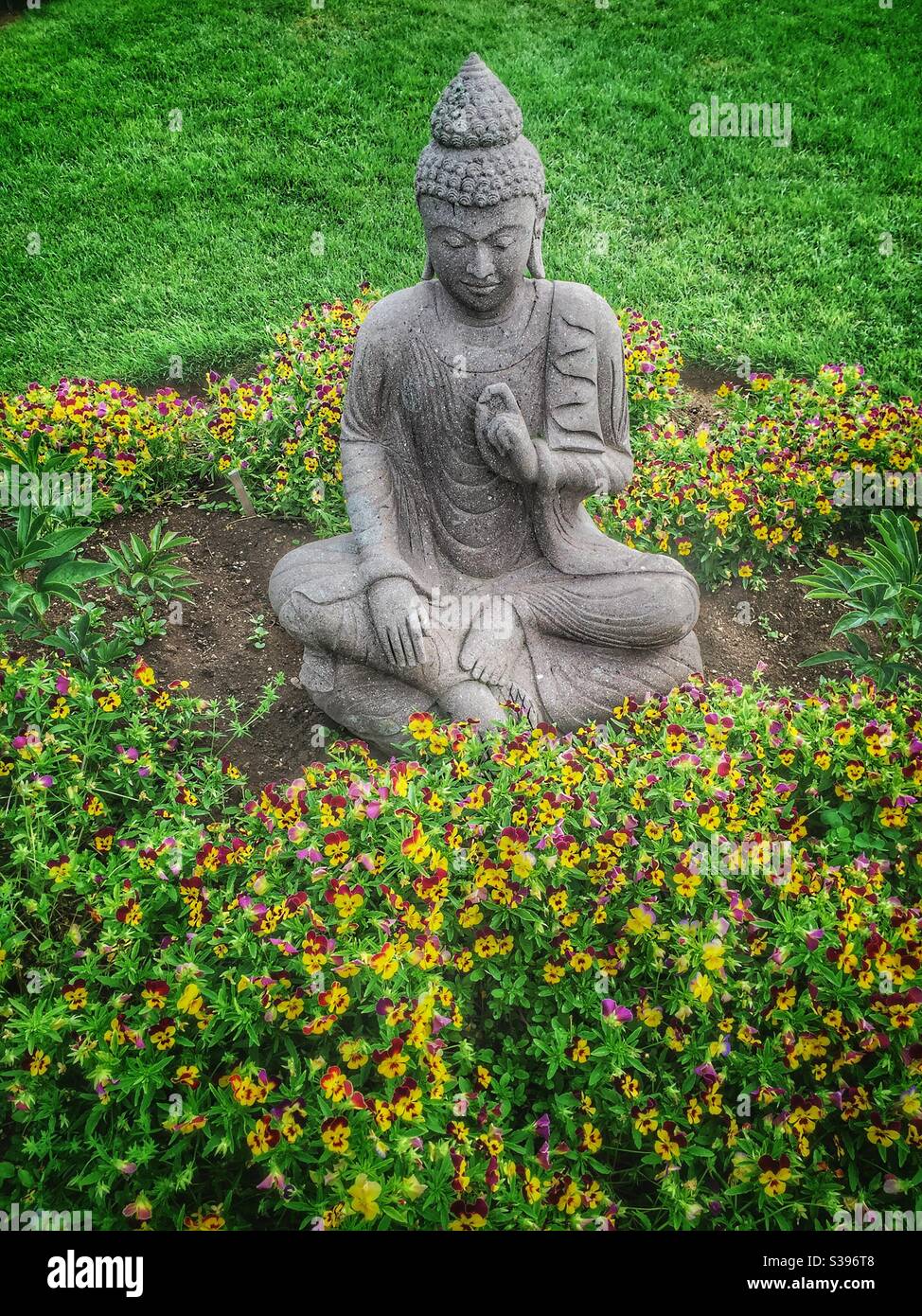 Buddha statuary has in a peaceful summertime garden. Stock Photo